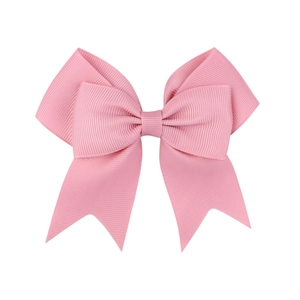 Detailed close-up of a handmade pink grosgrain ribbon hair bow for girls with textured fabric