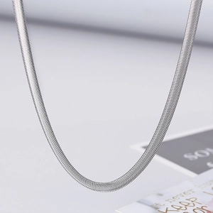 Macro detail of 5mm silver herringbone flat snake chain necklace with smooth metal texture