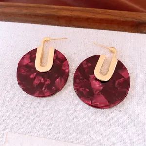 18K gold plated hoop earrings with dark red marble resin discs on beige fabric