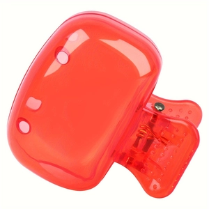 Close-up of a translucent red plastic hair claw clip with a glossy finish and metal spring