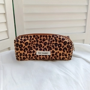 Close-up of leopard print makeup bag with metal zipper and fabric label detail