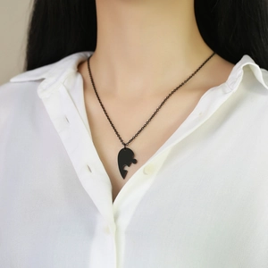 Black puzzle heart pendant necklace displayed on a model with white shirt