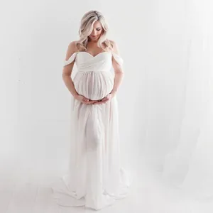 Close-up of white off-shoulder lace maternity photography gown with flowing chiffon skirt