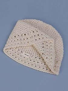 Detail of cream handmade crochet knit hat showing 100% cotton mesh texture and weave