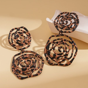 Macro view of leopard print cutout rose drop earrings with spiral hollow design
