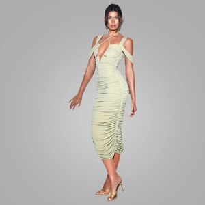Détail d'une robe moulante vert clair avec licou et texture en tissu froncé chic