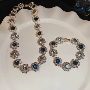 Macro shot of vintage silver floral jewelry set with blue gemstones on a white tray