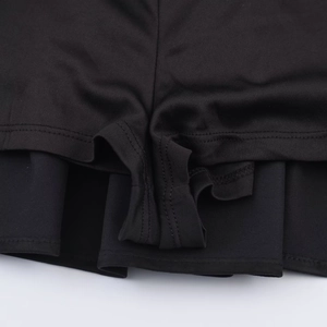 Gros plan détaillé du tissu en polyester noir et des coutures doubles sur l'ourlet du short
