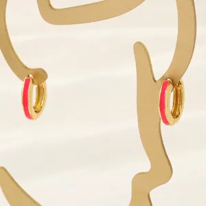 Detail of 18K gold plated hoop earrings featuring pink enamel on a metal silhouette