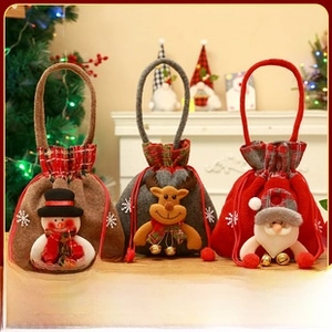Detailed view of three plush Christmas gift bags with snowman, reindeer and Santa designs