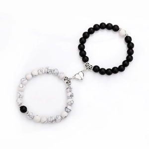 Detail of magnetic heart clasp connecting white marble and matte black beaded bracelets