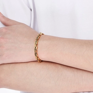 Close-up of golden bamboo link chain bracelet worn on wrist for minimalist fashion style
