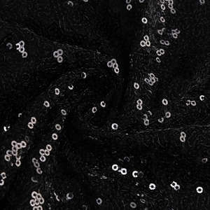 Close-up of sparkling black sequins and mesh texture on a sexy evening dress