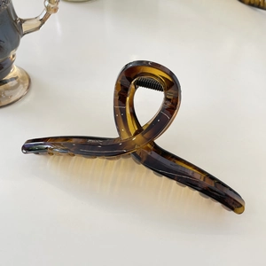 Close-up of amber tortoiseshell resin hair clip with glossy semi-transparent finish