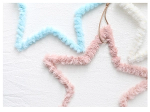 Close-up of soft plush star ornaments in pastel colors with fine furry texture