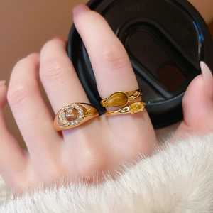 Close-up of vintage gold plated rings with tiger eye stone and zircon on a hand
