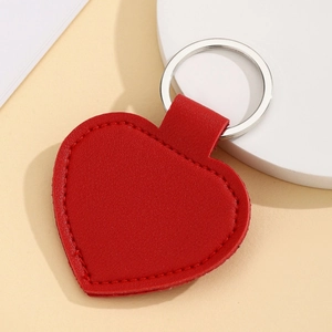 Close-up of a red heart-shaped PU leather keychain with a metal ring on a neutral background
