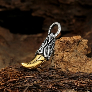Wolf tooth pendant in gold and silver finish on a rustic wooden background