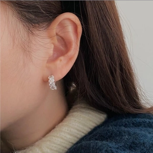 Close-up of 925 sterling silver hoop earrings with clear oval-cut zircon stones on model