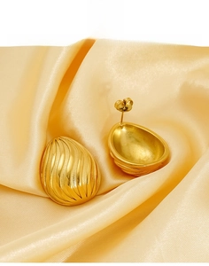 Detailed macro view of gold teardrop earrings with textured radial shell patterns