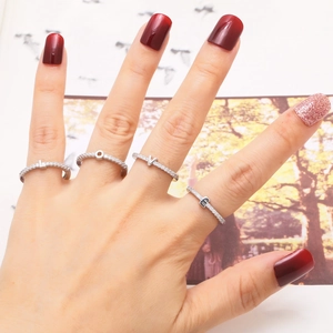 Silver LOVE initial rings with pavé stones on woman's fingers in a stylish setting