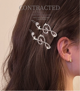 Detail of silver musical note hair clips with sparkling rhinestones in brown hair