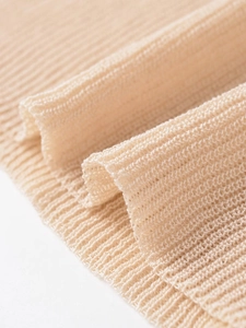 Close-up detail of soft apricot knitted fabric with vertical ribbed texture and fine weave
