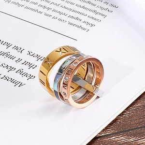 Close-up of titanium steel rings with Roman numeral engravings and rhinestone inlay
