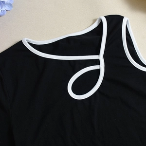 Close-up of contrast color-block knit top with cutout neckline and white piping detail