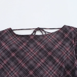 Detail of dark red plaid fabric featuring cross lace-up ties and textured weave