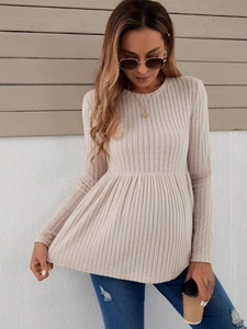 Detail of long sleeve maternity top in beige knit fabric with babydoll waist and pleats