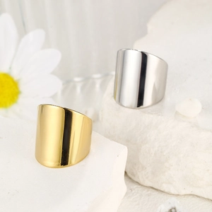 Polished gold and silver minimalist wide rings on white stone with daisy flowers