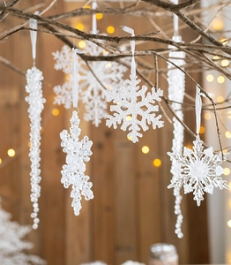 Detail of clear acrylic snowflake and icicle ornaments hanging with white ribbons