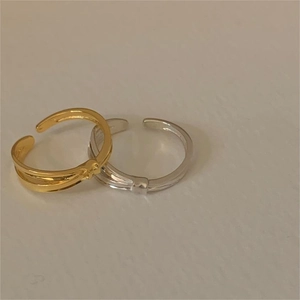 Detail view of gold and silver interlaced double-line rings with adjustable bands