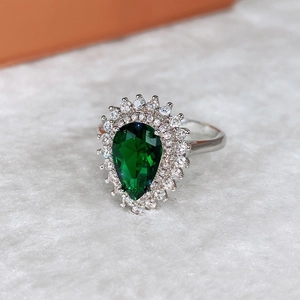 Macro di anello con zircone verde smeraldo a forma di pera con doppia incastonatura halo