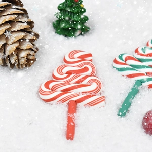 Close-up of candy cane and swirl tree decorations on artificial snow for DIY crafts