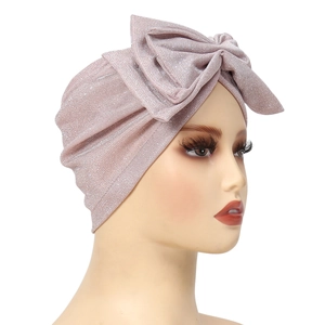 Detail of glittery pink bow turban cap showing shiny sequin texture and side profile