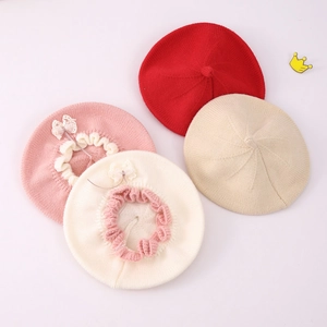 Detail showing knit berets with lace bows in red, beige, pink and white colors