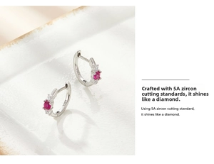 Close-up of 925 sterling silver hoop earrings with oval red zircon and side stones