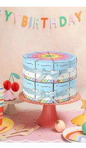 Detailed view of triangular party favor boxes arranged as a two-tier cake with ribbons