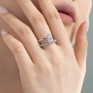 Close-up of a pear-cut teardrop diamond ring set with matching pave wedding band