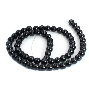 Macro shot of polished black agate round loose beads for DIY jewelry making and crafts