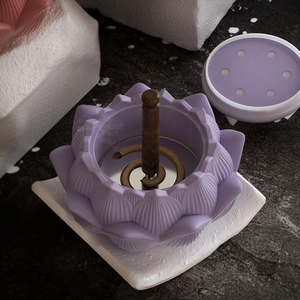 Detailed view of purple lotus incense holder with metal base on textured stone surface