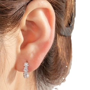 Star-shaped zircon silver hoop earrings featuring sparkling crystals on a model's ear
