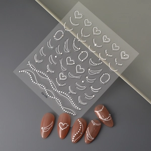 Detailed 3D embossed nail art stickers with pearls and hearts on nude pink manicure
