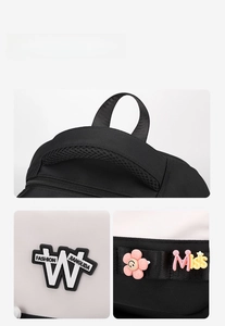 Detail of breathable padded handle and fashion patch on black and white school bag