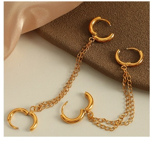 Detailed view of luxury gold double-layer chain hoop earrings on champagne silk fabric