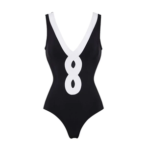 Detailed view of black one-piece swimsuit featuring a white infinity knot front and deep V-neck