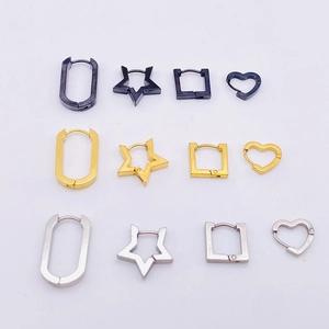 Detail of star, heart, square, and U-shaped earrings in black, gold, and silver finishes