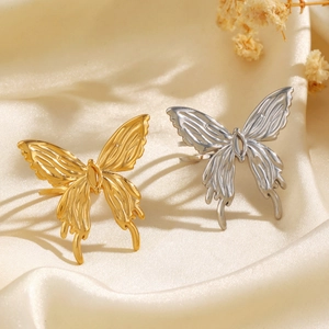 Minimalist thick butterfly rings in gold and silver finish on silk fabric background